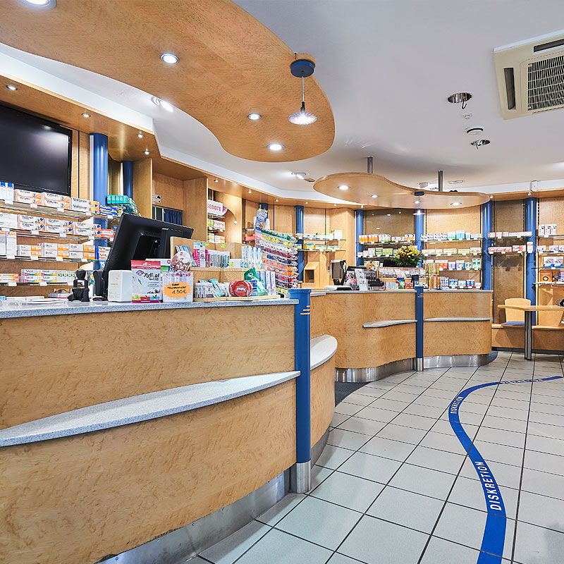 Moderne Apotheke mit hellen Regalen, einem Empfangstresen und freundlichem Ambiente.